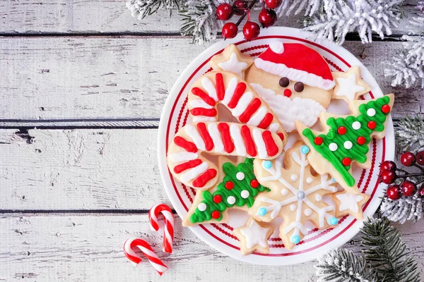 stock image Plate of cute decorated Christmas cookies. Above view table scene over a white wood background. Holiday baking concept.