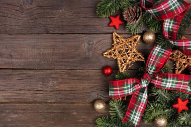 Noel süslemeleri, dallar, kırmızı ve yeşil ekose fiyonklar ve kurdeleler. Kırsal ahşap arka planda genel görünüm.
