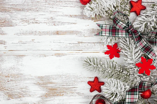 圣诞边缘由红色的装饰品 雪白的枝条和格子缎带组成 上面是白色的木制背景 复制空间 — 图库照片