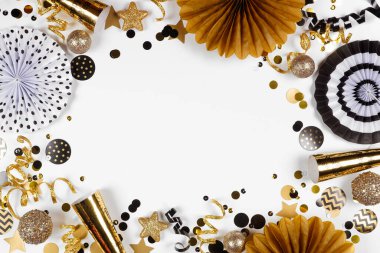 New Years Eve frame of gold and black confetti, noisemakers, streamers and decorations. Above view on a white background. clipart