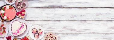 Valentines Day corner border of assorted desserts and sweets. Top view over a white wood background. Love and hearts theme. Copy space.