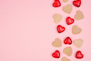 Valentines Day side border of wooden hearts and gems. Top view on a soft pink banner background. Copy space.