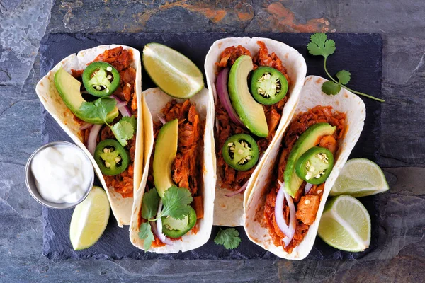 Jack fruit vegan tacos. Top view over a dark background. Healthy eating, plant-based pulled pork meat substitute.