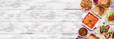 Healthy plant based vegetarian meal side border. Above view on a white wood banner background. Jackfruit tacos, zucchini lasagna, walnut bolognese zoodles, chickpea burgers, hummus, soup, salad.