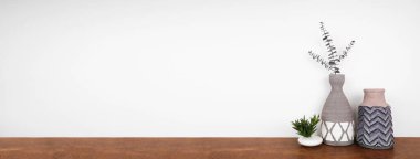 Ev dekorasyonu ve bitkiler bir rafta. Kil vazolar ve ahşap bir rafta beyaz bir duvara karşı sulu bitkiler. Kopyalama alanı olan pankart.