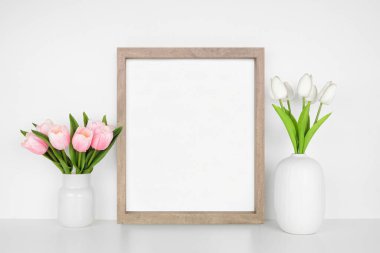 Bahar lale çiçekleriyle ahşap çerçeve yap. Beyaz bir duvara karşı beyaz bir raf. Boşluğu kopyala.