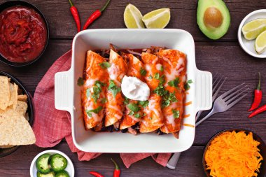 Fasulyeli tavuk enchilada. Meksika yemeği. Koyu bir ahşap zemin üzerine yatıyordu..
