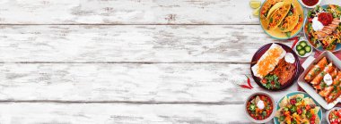 Meksika yemek sınırı. Beyaz ahşap bir arka planda tepeden aşağı manzara. Taco, burrito tabağı, nachos, enchilada, tortilla çorbası ve salata. Boşluğu kopyala.