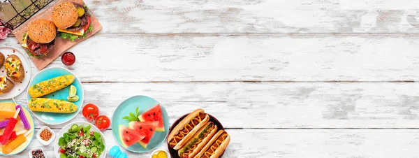 stock image Summer BBQ food corner border. Hamburgers, hot dogs, potatoes, corn and cold treats. Above view over a white wood banner background. Copy space.