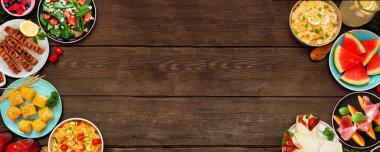 Yazlık yiyecek, koyu ağaç afişi üzerinde iki kat sınır çiziyor. Serinletici salatalar, meyve, ambalaj kağıtları ve barbekü şişleri. Genel bakış. Boşluğu kopyala.