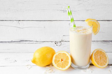 Limonlu, hindistan cevizli, limonlu smoothie. Beyaz ahşap zemin ile yan görünüm.