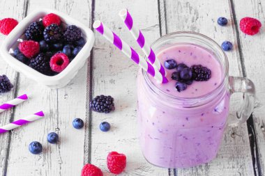 Duvarcı kavanozunda meyveli buzlu içecek. Masa sahnesini beyaz ahşap arka planlı kapat.