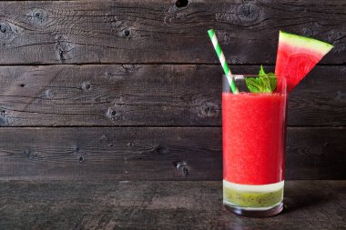 Katmanlı karpuz içeceğini tazeliyorum. Koyu renk ahşap arka plana karşı yan görüş. Yaz yemeği.