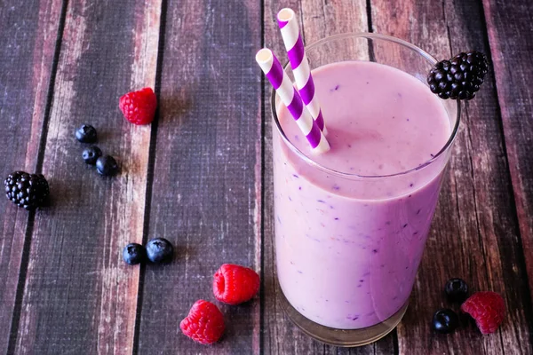 Karışık böğürtlen suyu. Koyu ahşap arka planlı masa sahnesini kapat.