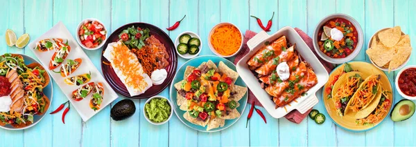 Meksika yemek masası sahnesi. Mavi ahşap arka planda tepeden aşağı manzara. Taco, burrito tabağı, nachos, enchilada, tortilla çorbası ve salata. Boşluğu kopyala.