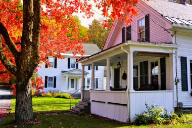 New England, ABD 'de sonbahar boyunca canlı kırmızı akçaağaç ağaçlı beyaz ahşap evler