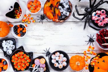 Cadılar Bayramı şeker mi şaka mı? Ürkütücü şeker koleksiyonu. Kopya alanı olan beyaz tahta arkaplan üzerindeki üst görünüm.