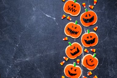 Cadılar Bayramı Jack o Lantern kurabiye kenarı sınırı. Fotokopi alanı olan karanlık bir taş arkaplan üzerinde genel görünüm.