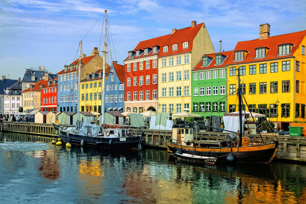 Colorful waterfront buildings and ships along the historic Nyhavn canal with reflections, Copenhagen, Denmark