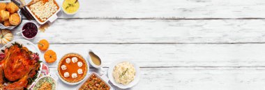 Geleneksel Şükran Günü hindi yemeği. Beyaz ahşap bir arka planda üst köşenin kenarı. Hindi, patates püresi, dolma, balkabağı turtası ve yanında.