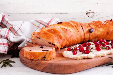 Nar krem peynirli yaban mersinli baget. Masa sahnesi beyaz ahşap arka plana karşı. Kış ya da Noel temalı aperatif.