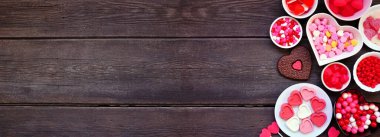 Sevgililer Günü 'nün sınırında bir sürü şeker var. Fotokopi alanı olan koyu ahşap bir arkaplanda görünümün üzerinde.