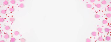 Sevgililer Günü 'nde şeker kalpler ve şekerlerden oluşan çifte sınır. Beyaz afiş arkaplanındaki manzaranın üstünde. Boşluğu kopyala.