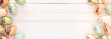 Altın benekli Paskalya yumurtası çifte sınır. Beyaz ahşap bir arkaplanda manzaranın üstünde. Boşluğu kopyala.