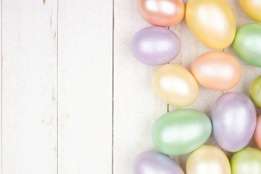 Paskalya yumurtası, beyaz ahşap arka planda. Parlak pastel yumurtalar. Boşluğu kopyala.
