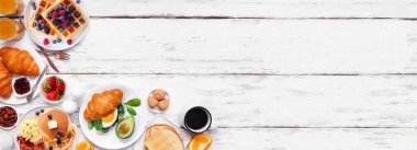 Beyaz ahşap bir arka planda kahvaltı ya da brunch köşesi sınırı. Genel bakış. Tatlı ve lezzetli yiyecek çeşitleri..