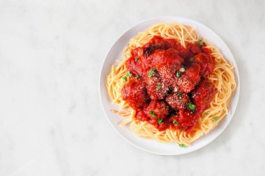 Ev yapımı spagetti ve domates soslu köfte. Beyaz mermer arka planda üst görünüm.