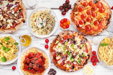 Lezzetli İtalyan yemek masası sahnesi. Pizzalar ve pastalar. Beyaz ahşap zemin üzerinde görünüm.