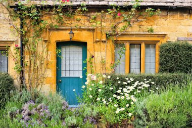 Büyüleyici Cotswold 'ların evi çiçeklerle kaplı, Gloucestershire, İngiltere