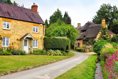 Güzel Cotswold köyü sazdan çatı ve çiçeklerle kaplı Stanton, Gloucestershire, İngiltere