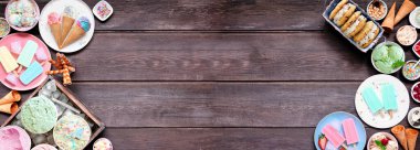 Serin yaz yemekleri çifte sınır. Dondurma, buzlu şeker ve dondurulmuş şeker karışımı. Pastel renkler. Koyu ahşap bir arkaplanda genel görünüm.