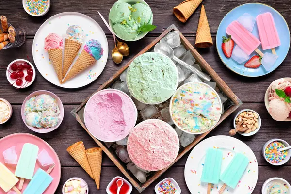 涼しい夏の食卓のシーン アイスクリーム ポップス 冷凍トリートの品揃え パステルカラー ダークウッドの背景にあるトップダウンビュー ロイヤリティフリーのストック写真