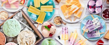 Harika bir yaz yemeği masası sahnesi. Çeşitli ferahlatıcı dondurma, buzlu şeker ve dondurmalar. Beyaz ahşap bir arkaplanda aşağıdaki görünüm.