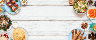 Yaz Akdeniz temalı yiyecekler çifte sınır. Fotokopi alanı olan beyaz ahşap bir arkaplanda üst görünüm. Izgara şiş, salata, aperatif, pide ve tzatziki..