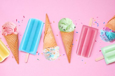 Renkli pastel yazlık dondurma külahları ve dondurmalı dondurma çeşitleri. Üst aşağı görünüm düz yumuşak pembe bir zemin üzerinde yatıyordu.