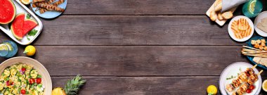 Yaz yemekleri et şişleri, salata, meyve ve atıştırmalıklarla sınırlandırılır. Koyu ahşap bir arkaplanda manzaranın üstünde. Boşluğu kopyala.