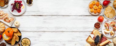 Sonbahar temalı aperatif beyaz ahşap bir arka planda çift kenar. Şarküteri tahtası, balkabağı ve elma sosu, crostini, peynir ve aperatif. Genel Görünüm.