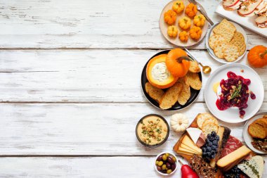 Sonbahar temalı aperatifler beyaz ahşap arka planda karşı kenar. Şarküteri tahtası, balkabağı ve elma sosu, crostini, peynir ve aperatif. Üst görünüm.