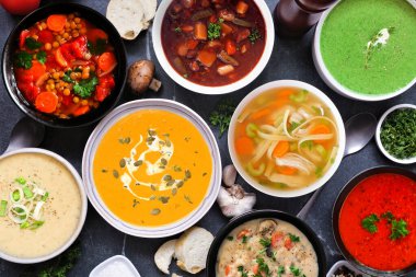 Lezzetli ev yapımı çorba seçimi. Koyu bir arka planda, yukarıdan görünüşlü masa sahnesi. Sıcak ve samimi yiyecek konsepti.