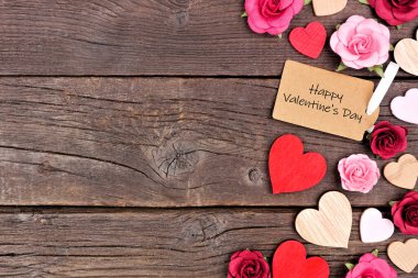 Sevgililer Günü 'nde tahta kalpler ve kağıt güller ile Sevgililer Günü hediye etiketi. Koyu renk ahşap arka planda üst manzara. Boşluğu kopyala.
