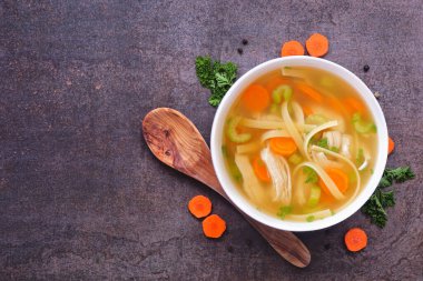 Ev yapımı tavuklu şehriye çorbası, üstten görünüm masası sahnesi malzeme çerçevesi ve koyu arkaplan üzerine fotokopi alanı.