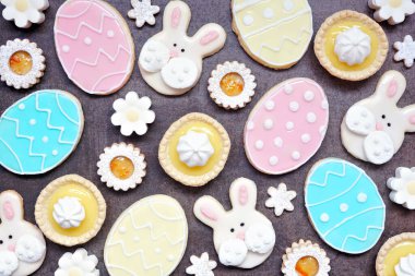 Paskalya ya da bahar temalı fırın arka planında çeşitli kurabiyeler ve tatlı tatlılar. Koyu taştan bir arkaplanda üst görünüm.