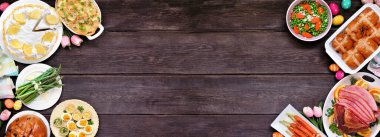 Geleneksel Paskalya jambonu yemeği. Karanlık ahşap kaplamalı arka planda kopya alanı olan çift kenarlı görünüm üzerinde. Jambon, istiridyeli patates, sebze tabağı, yumurta, ekmek ve limonlu tatlı..