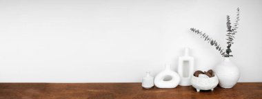 Modern vazolar ve ahşap bir rafta beyaz bir duvara karşı ev dekorasyonu. Kopyalama alanı olan pankart.
