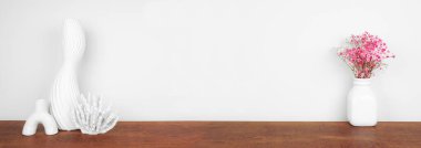 Beyaz bir duvara karşı ahşap bir rafta ev dekorasyonu. Kopyalama alanı olan pankart.