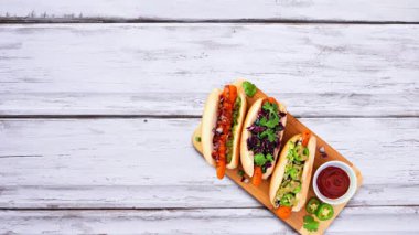 Sağlıklı bitki temelli vejetaryen gıda, hareket masasını durdurur. Beyaz ahşap arka planda üst manzara. Jackfruit burger, mantarlı taco, karpuz ve karnabahar bifteği, havuç sosisi, cevizli bolonez